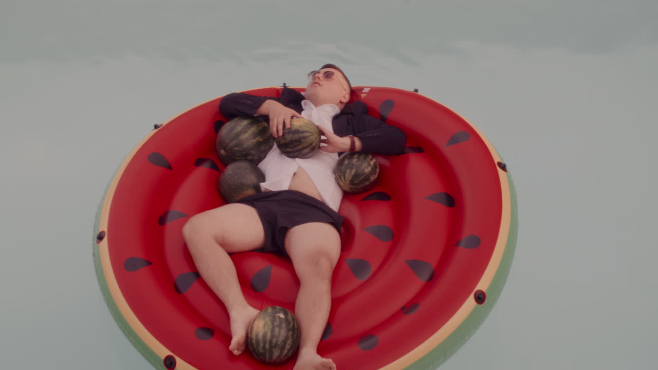 Man Relaxing on Watermelon Pool Float