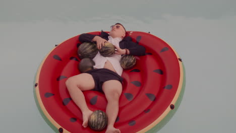 man relaxing on watermelon pool float