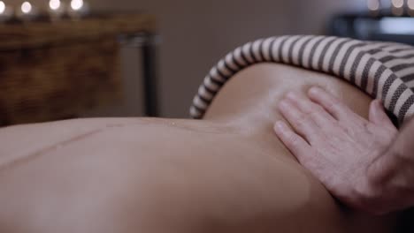 Close-up-of-woman-receiving-a-back-massage-from-a-professional-masseuse