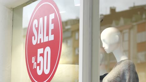 store window display with 50% off sale sign