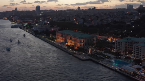 Beautiful-Ciragan-Palace-Kempinski-on-Riverside-of-Bosphorus-in-Istanbul-at-Dusk,-Aerial-View