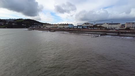 Toma-Panorámica-Derecha-Del-Paseo-Marítimo-De-Teignmouth-Devon,-Inglaterra-En-Un-Tormentoso-Día-Nublado