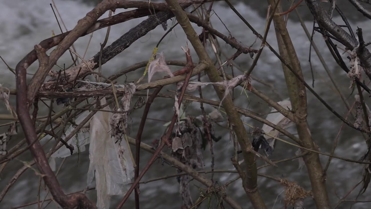 Inquinamento da plastica su un fiume dopo le inondazioni. Carrellata