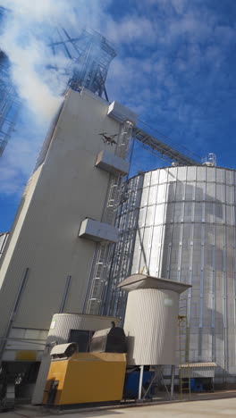 grain elevators outdoors. aluminum containers for storing grain. agribusiness. vertical video