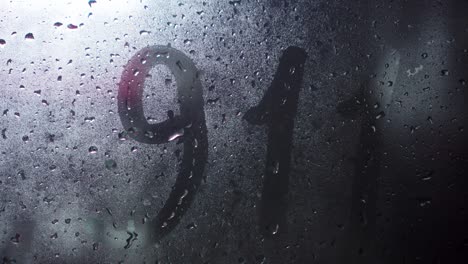 inscripción manuscrita en inglés 911 en vidrio frosted empañado.