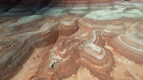 Aerial-View-of-Person-Running-Under-Bentonite-Hills-in-Desert-Landscape-Near-Hanksville,-Utah-USA