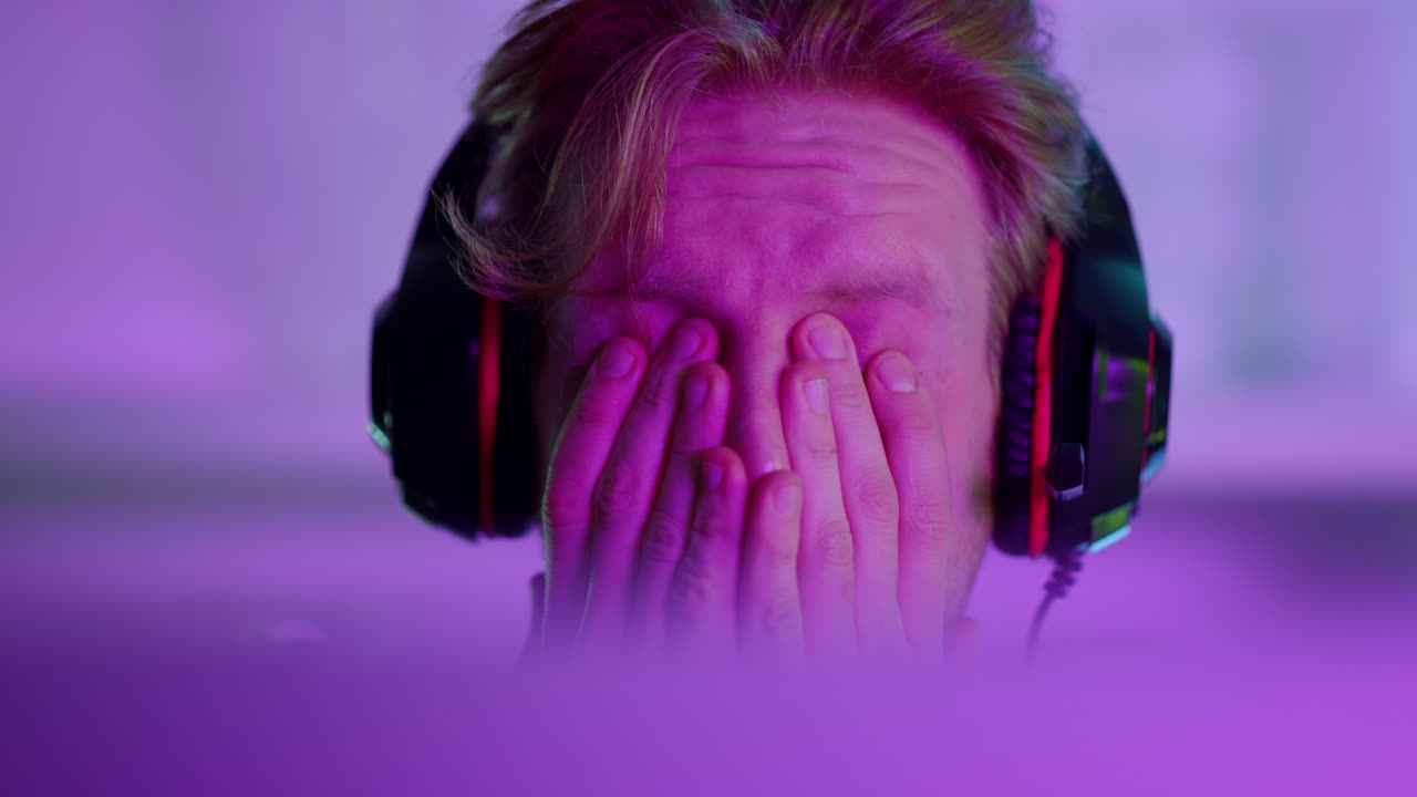 사이버맨이 네온 조명 클로즈업에서 게임을 잃고 있습니다. 좌절된 에스포트 전문가