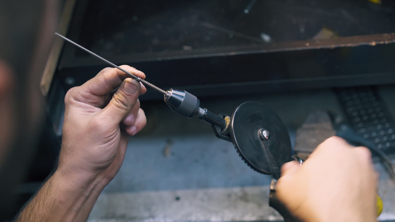joyero bobinas de alambre de oro girando el mango de la herramienta vista de cerca