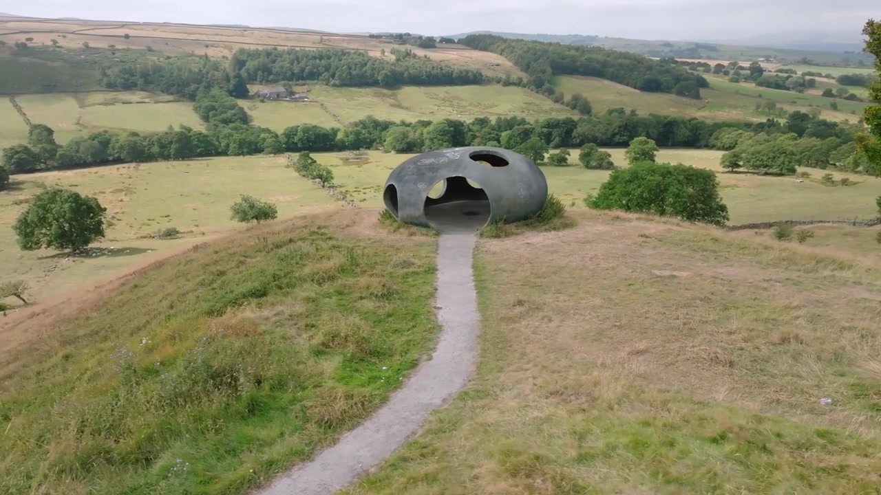 L'Atom Panopticon, Wycoller, Pendle, Lancashire, Regno Unito. Rivelato da un albero che mostra l'aspetto collinare dell'opera d'arte e la valle più ampia