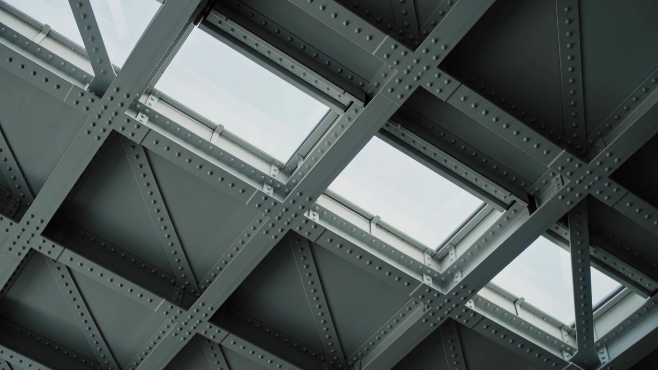 Tilting camera revealing riveted steel ceiling at station roof, showing skylights and rivets