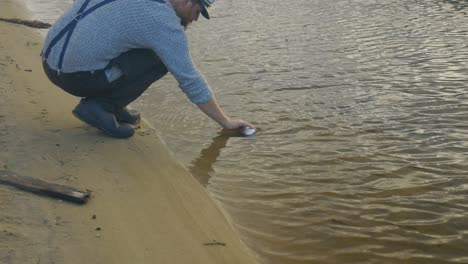 close up of a 1900s sailor collecting water from a coastal creek