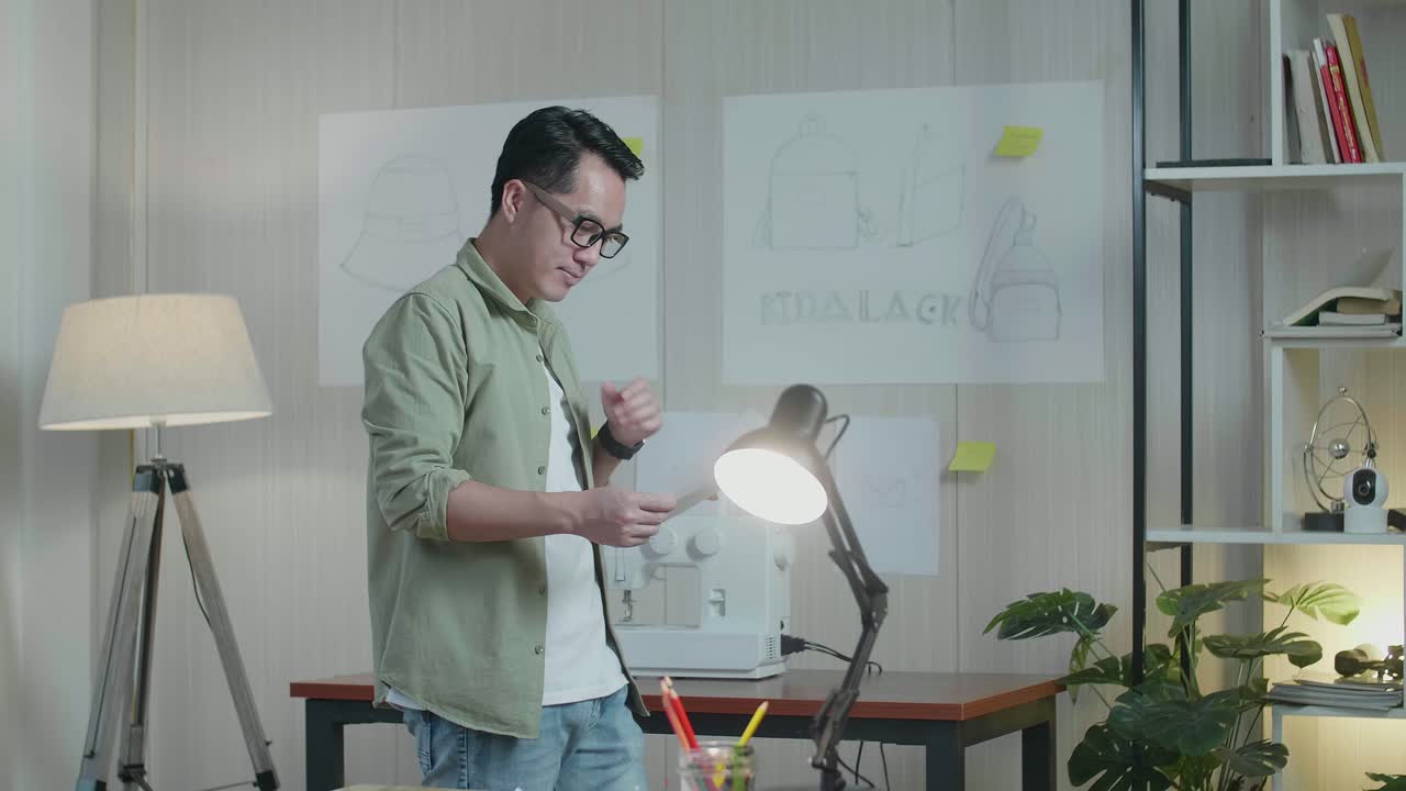 아시아 남자 디자이너는 레이아웃을 보면서 생각하고 사무실에서 고 있습니다.