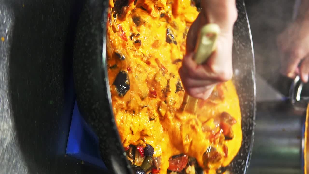 comida española comida española tiro vertical que se agita y se mezcla en una olla, estofado con salsa y carne muy apetecible