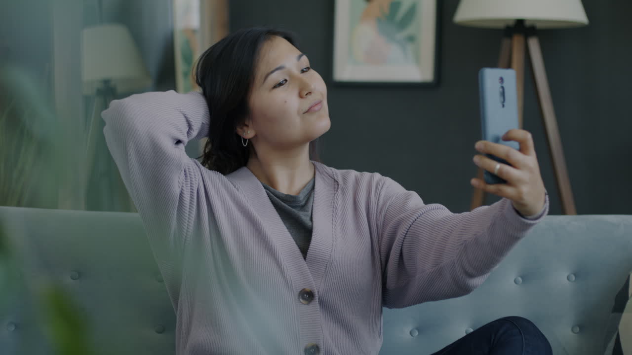 Woman taking a selfie on a couch