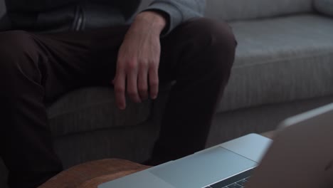 Man-working-from-home-is-typing-on-laptop-then-drinking-from-a-mug