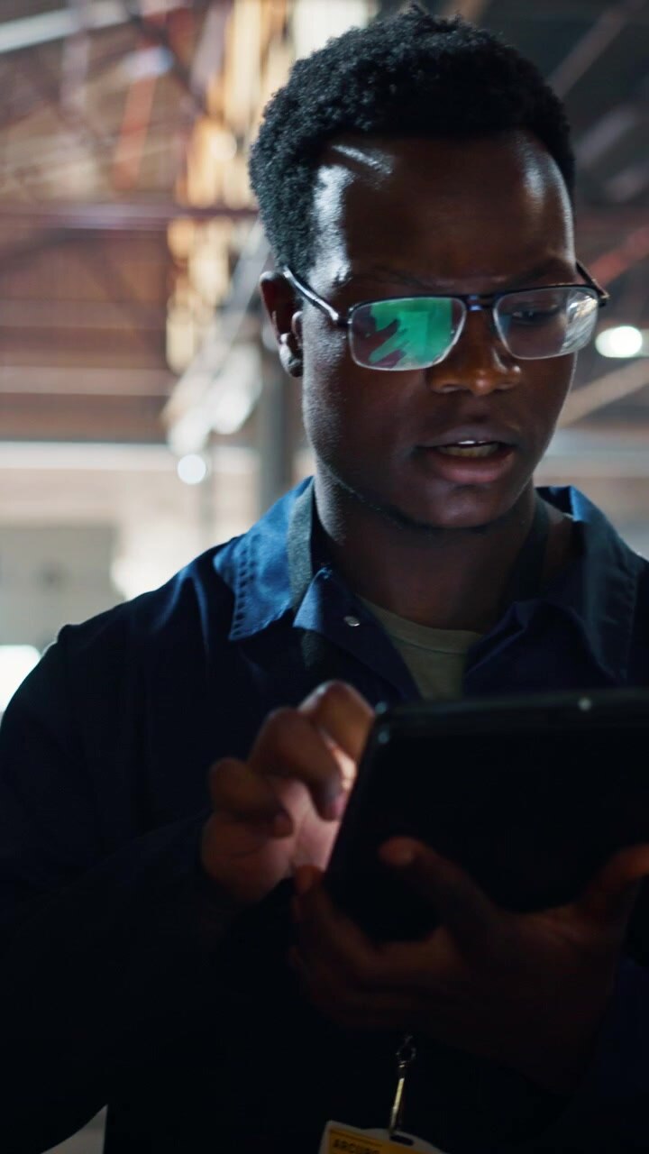 Construction Worker Using Digital Tablet in Warehouse