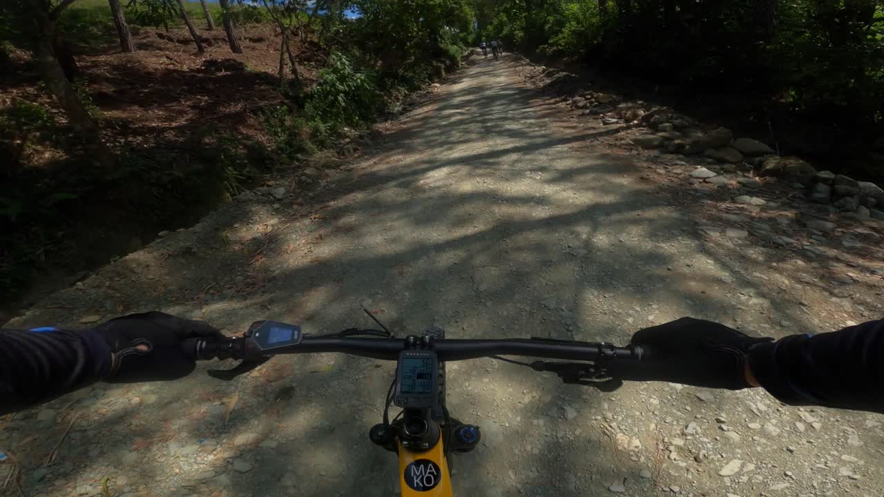 First-person pov of yellow electric mountain bike racing on rural rough road