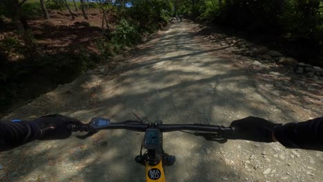 first-person pov of yellow electric mountain bike racing on rural rough road