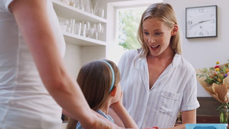 same sex female couple with daughter preparing meal at home together