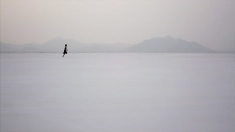 antena dramática de un niño corriendo en el desierto de sal de utah