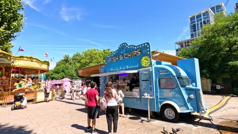 people walking near carousel and food truck