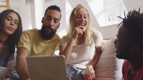 dos parejas riendo juntas mirando en la computadora portátil