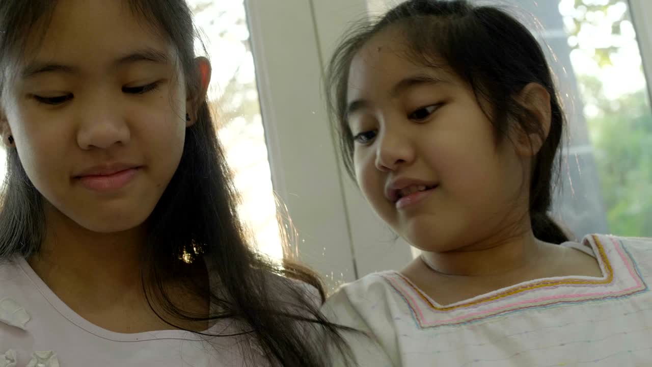 4k 아시아 소녀들이 스마트폰에서 게임을 하고, 함께 행복한 시간을 보내고 있습니다.