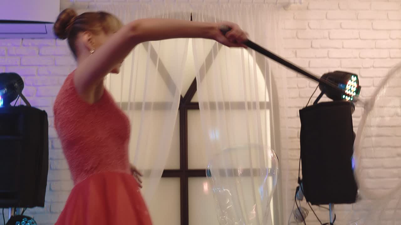 una niña linda jugando con grandes burbujas de jabón haciendo un espectáculo en primer plano