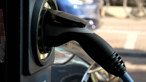 cargando un coche eléctrico con un cable de alimentación en la estación de carga 4k