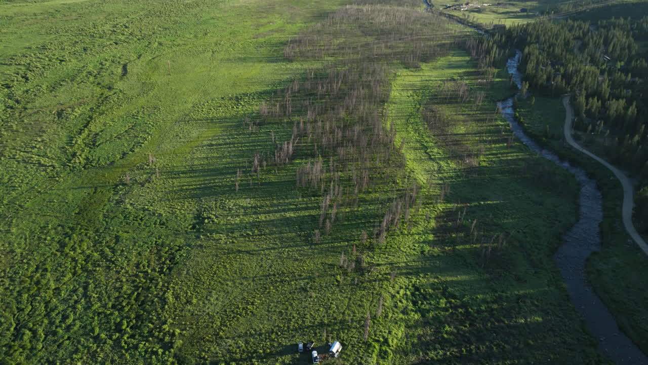 Tilting drone shot of a meadow near Shadow Mountain Lake at sunrise in the Rocky Mountains of Colorado