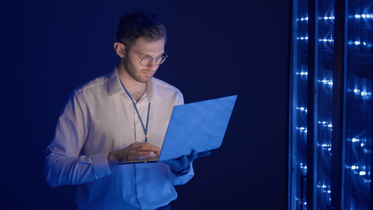 ingeniero de servidor masculino en un centro de datos. ingeniero de it inspeccionando un gabinete de servidor seguro usando tecnología moderna laptop coworking en un centro de datos.
