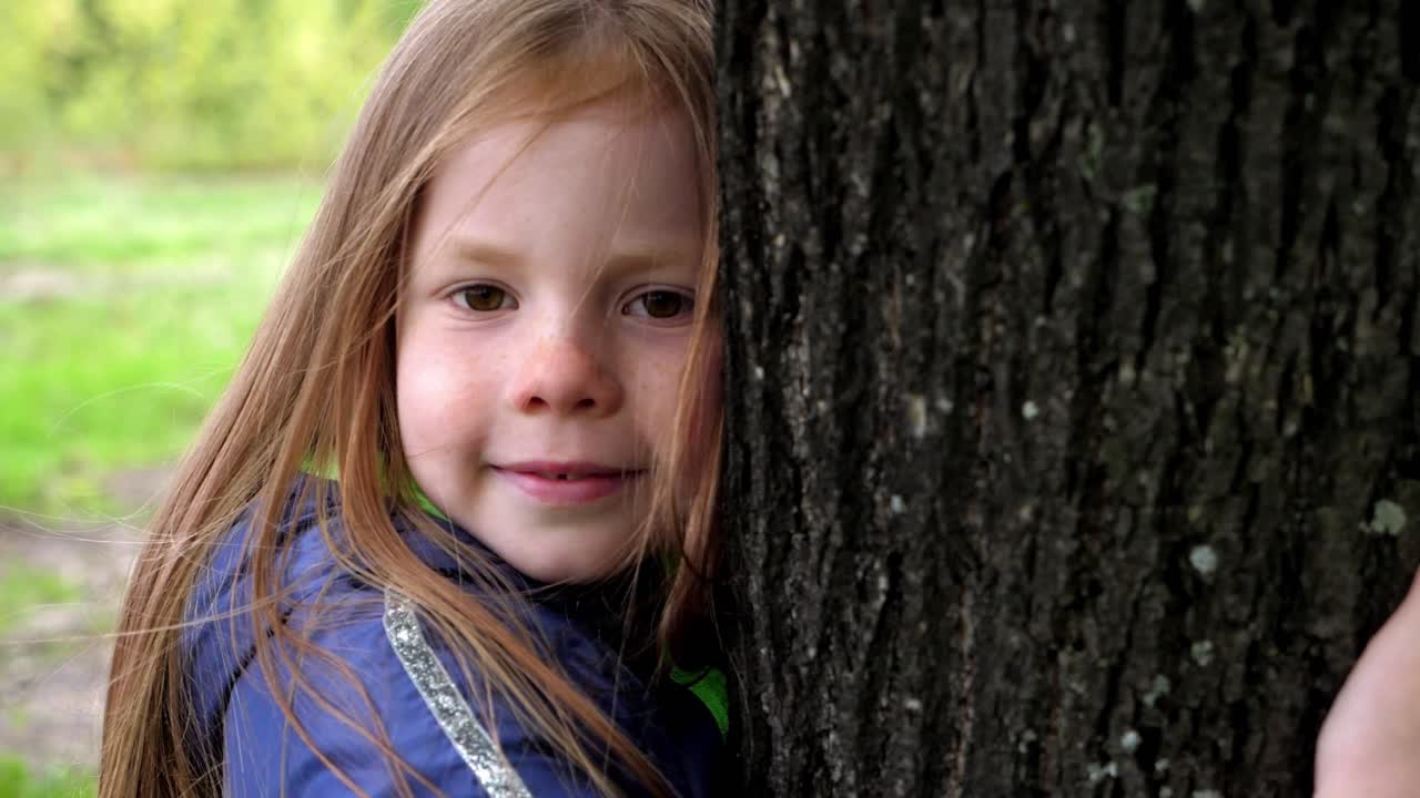 Child hugging a tree in park