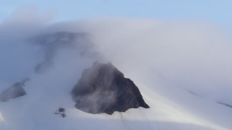 montaña cubierta de nieve en las nubes, península de snaefellsnes, islandia, zoom out