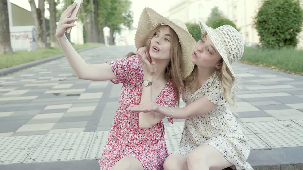 도시 공원에서 셀피를 찍는 두 친구