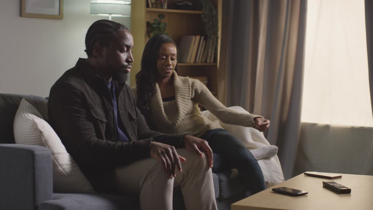 Couple At Home Sitting On Sofa In Lounge Having Break Up Argument 9