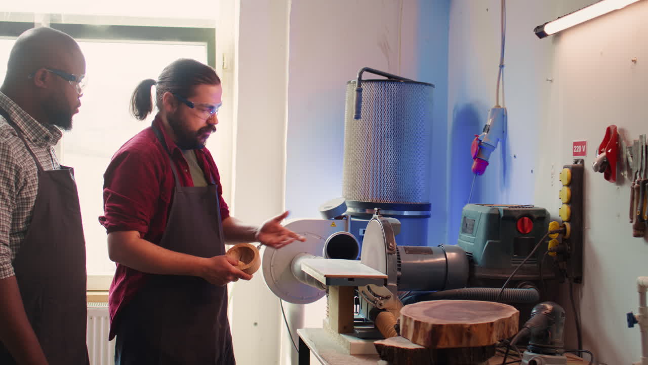 рабочий, изучающий у специалиста по деревообработке, как использовать шлифовальную машину