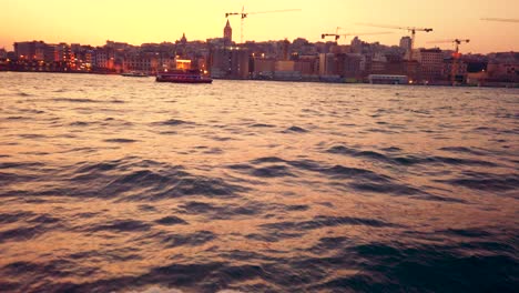 slow motion: landscape view of galate tower and bosphorus at sunset while cruising in istanbul,turkey