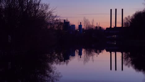 Una-Hermosa-Atardecer-Sobre-Un-Lago-Con-Las-Chimeneas-Del-Fondo-De-La-Industria