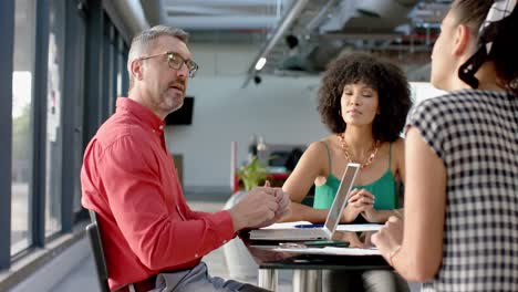 team of diverse colleagues discussing while sitting together at office