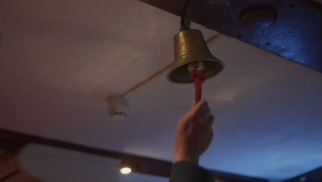 a man ringing a bell above a bar