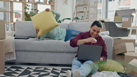 Pillow-fight,-new-home-and-couple-on-sofa