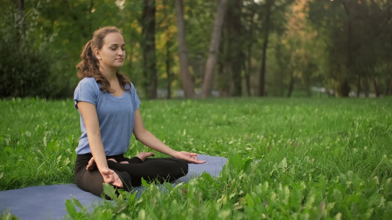 mujer joven haciendo ejercicio de meditación sentada en la hierba. mujer estirándose
