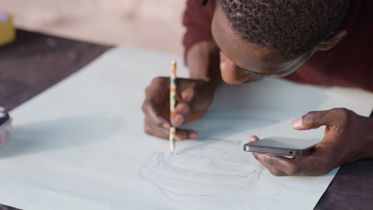 Overhead artist mapping composition paper, pencil tracing concentric lines while checking phone reference frames show roles as designer, cartographer, patternmaker, illustrator, planner steady hands