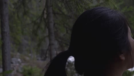 girl looking at a river in the forest