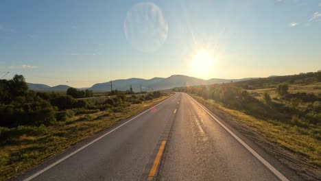 driving a car on a road in norway at dawn.