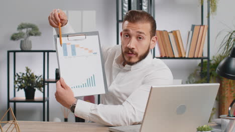 business man making online presentation video call demonstrates graphic analytics looking at camera