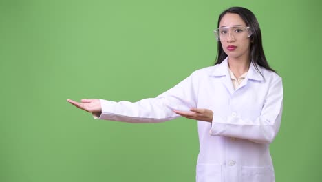 una joven y hermosa mujer asiática, doctora, con gafas de protección.