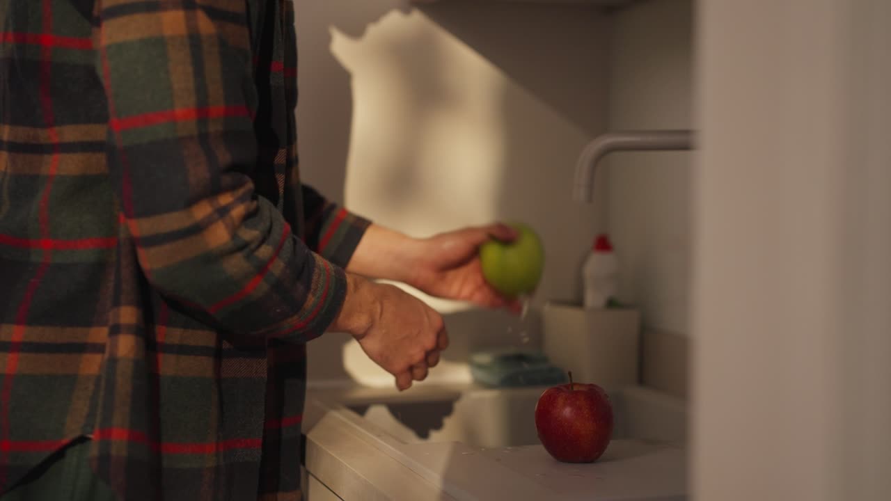 Person washing apples in the kitchen sink