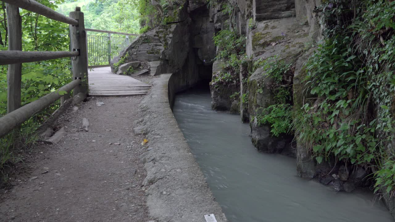 A hiking trail next to an irrigation canal carrying water used for agricultural purposes.