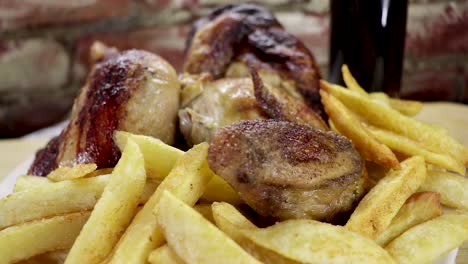 dolly out, primer plano medio sobre pollo asado completo y papas fritas